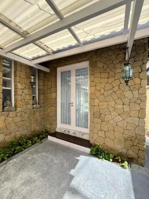 a house with a stone wall and a glass door at villa Bunga in Seminyak