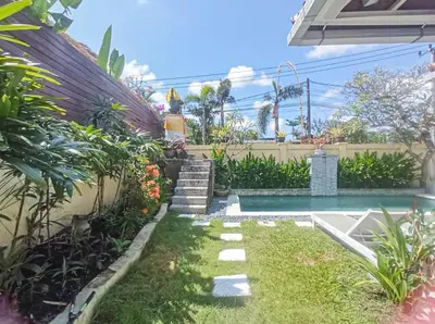 a backyard with a swimming pool and a garden at villa Bunga in Seminyak