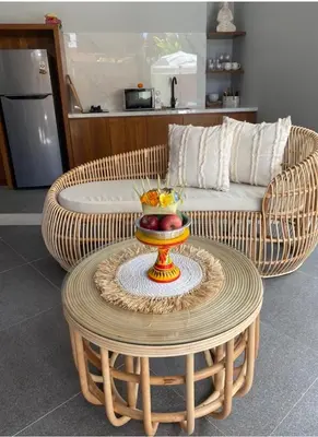 a wicker couch and a table with a bowl of fruit on it at Villa Sooni 1 in Seminyak