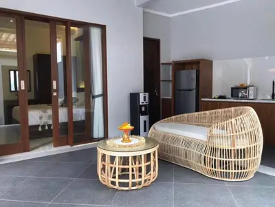 a living room with a wicker chair and a table at Villa Sooni 1 in Seminyak