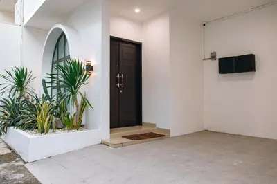 a front door of a house with two plants at Casa Yo-Na Seminyak in Seminyak