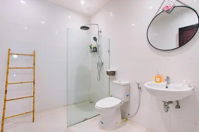 a bathroom with a toilet and a sink and a mirror at Casa Yo-Na Seminyak in Seminyak