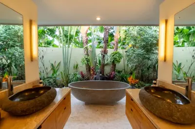 two sinks in a bathroom with a tub and plants at Spacious Charming 4BR Balinese Villa, Seminyak in Kerobokan