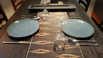 a wooden table with plates and utensils on it at Hanupis Canggu Apartment in Canggu
