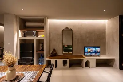 a living room with a table and a mirror at Hanupis Canggu Apartment in Canggu