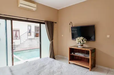 a bedroom with a flat screen tv and a bed at Unique Villa Jimbaran in Jimbaran