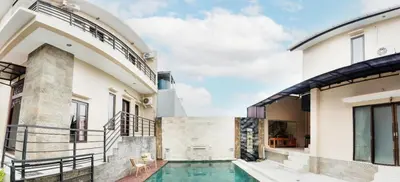 a house with a swimming pool next to a building at Unique Villa Jimbaran in Jimbaran