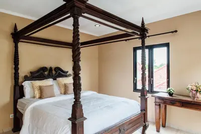 a bedroom with a canopy bed and a window at Unique Villa Jimbaran in Jimbaran