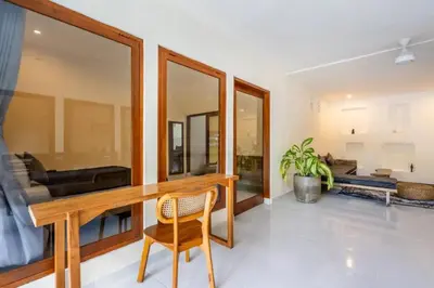 a living room with a wooden desk and a chair at Villa Durna 2 in Seminyak