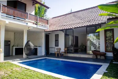 a villa with a swimming pool in front of a house at Villa Durna 2 in Seminyak