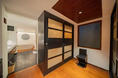 a room with a door and a chair in it at Villa Ramadewa Beachside with Authentic Charm in Seminyak