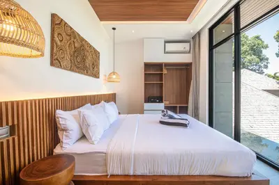 a bedroom with a bed and a large window at Tropical 5BR Modern Haven 400m from Canggu in Canggu