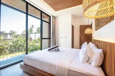 a bedroom with a large bed with a large window at Tropical 5BR Modern Haven 400m from Canggu in Canggu