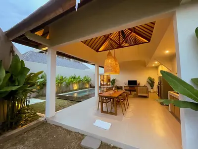 a dining room and living room of a house with a dining table at Villa Sinergi Seminyak 7 in Seminyak