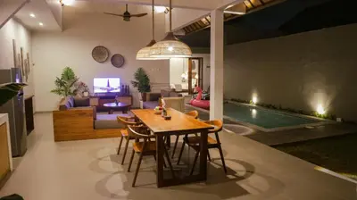 a dining room and living room with a table and chairs at Villa Sinergi Seminyak 8 in Seminyak