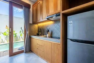 a kitchen with a sink and a refrigerator and a window at Villa Baile Bali by Great Bali Villas in Jimbaran