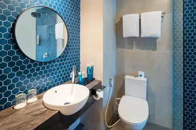 a bathroom with a sink and a toilet and a mirror at Quest Vibe Dewi Sri Bali in Legian