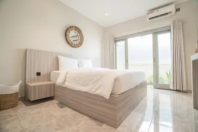 a bedroom with a large bed and a large window at Villa Mentari at Umalas in Kerobokan