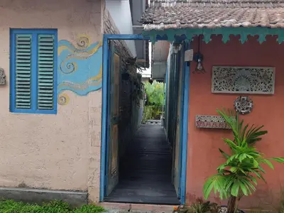 an alley in an old house with a blue door at HI Lonny Villa Seminyak in Seminyak