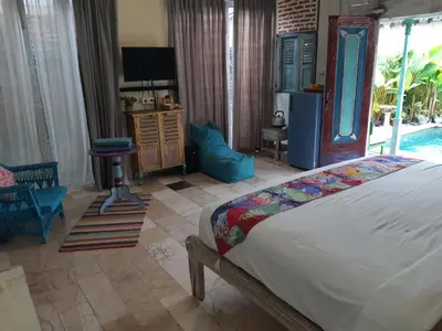 a bedroom with a bed and a pool at HI Lonny Villa Seminyak in Seminyak