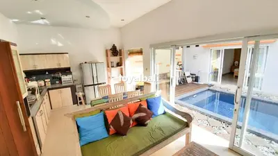 a living room with a couch and a swimming pool at Villa GOwen in Jimbaran