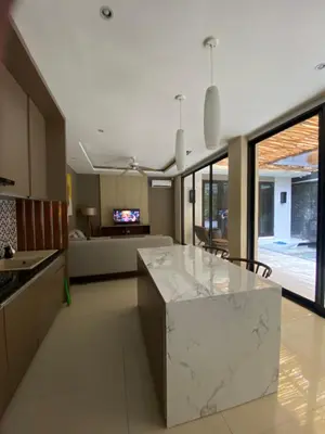 a kitchen with a marble counter top and a living room at Vila Samatha 2 Nusa Dua in Nusa Dua