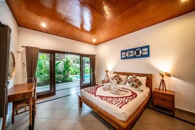 a bedroom with a bed and a desk at Villa Kusuma 1 Seminyak in Seminyak