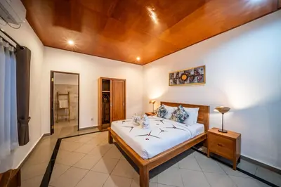 a bedroom with a large bed with a wooden ceiling at Villa Kusuma 1 Seminyak in Seminyak