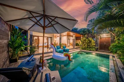 a swimming pool with an umbrella and a water slide at Villa Kusuma 1 Seminyak in Seminyak