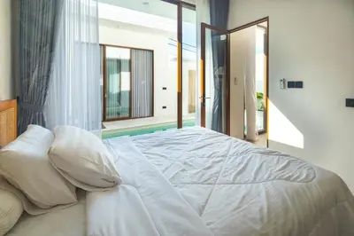 a white bed in a bedroom with a balcony at NEW! Villa Imaera - 2BR Villa in Kerobokan in Kerobokan