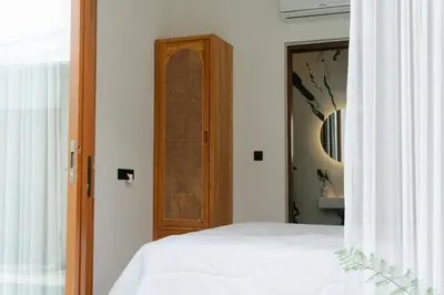 a bedroom with a bed and a wooden door at NEW! Villa Imaera - 2BR Villa in Kerobokan in Kerobokan