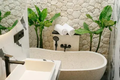 a bathroom with a white sink and a stone wall at NEW! Villa Imaera - 2BR Villa in Kerobokan in Kerobokan