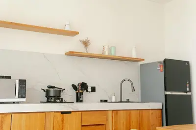a kitchen with a sink and a microwave and a stove at NEW! Villa Imaera - 2BR Villa in Kerobokan in Kerobokan