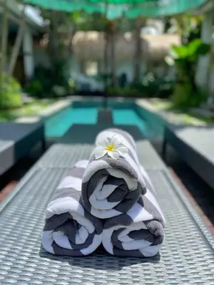 a pile of towels sitting next to a swimming pool at Villa Mint, 3Br Tropical Escape, Near Bintang Supermarket in Seminyak