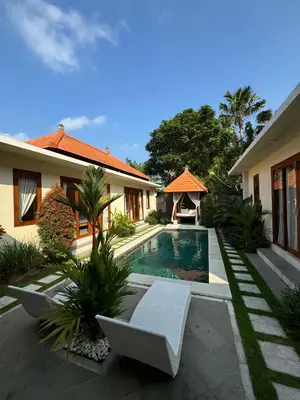 a villa with a swimming pool in front of a house at Ocean Cantik Villa in Canggu