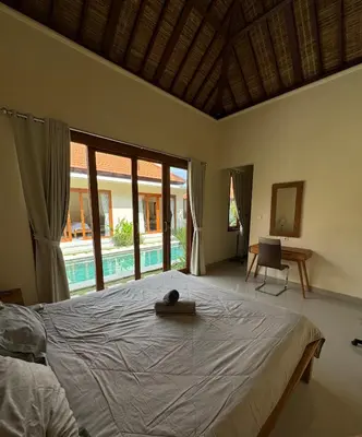 a bedroom with a large bed and a pool at Ocean Cantik Villa in Canggu