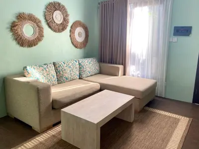 a living room with a couch and a coffee table at Palm Light Nusa Dua in Nusa Dua