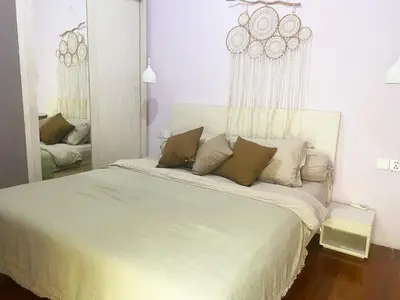 a white bed in a room with a mirror at Palm Light Nusa Dua in Nusa Dua