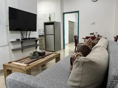 a living room with a couch and a tv at Beachview Residence in Seminyak