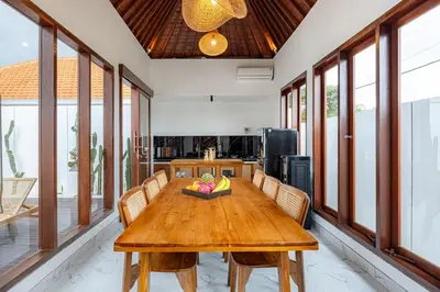 a dining room with a wooden table and chairs at Brand New Serene Balinese Villa with Private Pool in Kerobokan