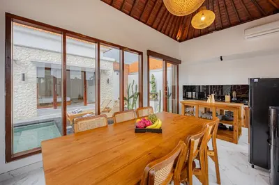 a dining room with a wooden table and chairs at Brand New Serene Balinese Villa with Private Pool in Kerobokan
