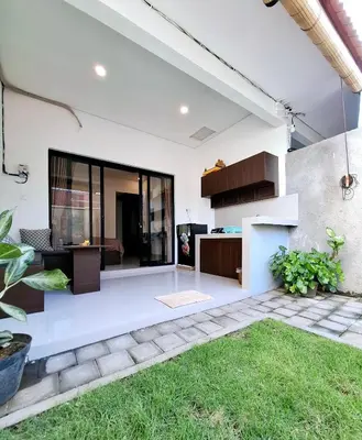 a modern house with white walls and a yard at Wisman House by Pigeon in Jimbaran