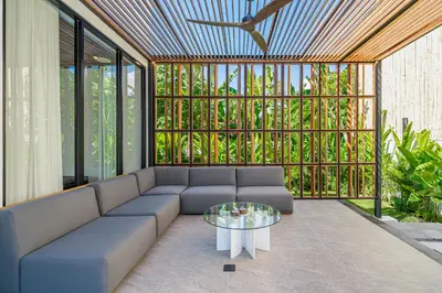 a living room with a couch and a glass table at Bedawang, Exquisite Seminyak 4BR Villa with Huge Pool in Seminyak