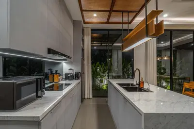 a kitchen with marble counter tops and a sink at Bedawang, Exquisite Seminyak 4BR Villa with Huge Pool in Seminyak
