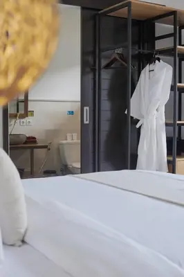 a bedroom with a bed and a dress on a rack at Villa Mint Dua, Peaceful 3BR Villa - Near La favela Seminyak in Seminyak