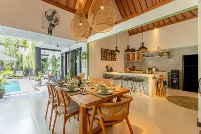 a kitchen and dining room with a wooden table and chairs at Villa Mint Dua, Peaceful 3BR Villa - Near La favela Seminyak in Seminyak