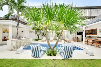 a villa with a palm tree and a swimming pool at Villa Mawali in Legian