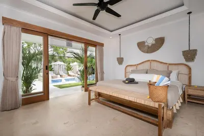 a bedroom with a bed with a ceiling fan at Villa Mawali in Legian