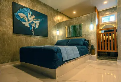 a bedroom with a bed with a painting on the wall at Amshiga 4 in Jimbaran