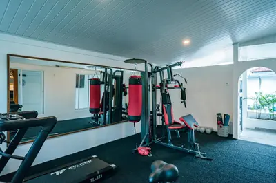 a gym with a mirror and some equipment in it at Amshiga 4 in Jimbaran